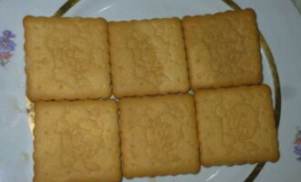 Place the cookie base on a large plate. Adjust the size of the cake and, accordingly, the number of cookies laid out yourself.