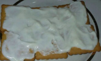 Cubra las galletas con la crema agria preparada.