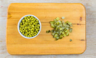 Pickled cucumbers contain a lot of liquid, so we cut them and leave them to drain so that the salad is not watery.