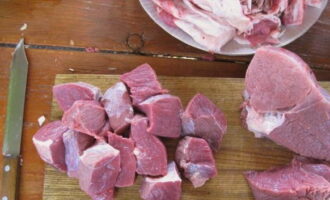 Como preparar shurpa de carne de acordo com a receita clássica? Corte a carne em pedaços quadrados grandes. Coloque a carne no caldeirão. Adicione sal, água e especiarias.