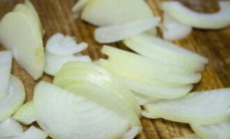 How to cook fried potatoes with mushrooms in a frying pan? Peel the onion, cut into half rings and fry in vegetable oil.