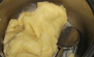 When the entire amount of flour has been added, the choux pastry will be thick and shaped. With continuous stirring, heat it on the stove for another two to three minutes. Then remove the pan from the stove and let the mass cool to about sixty degrees.