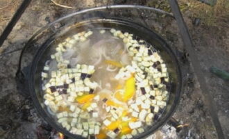 Cortar la berenjena en cubos pequeños y colocar también en el caldero. No es necesario pelar la verdura.