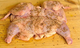 Sprinkle the chopped carcass with salt on both sides, rubbing it in with your hands to distribute it evenly. Then pour in the prepared spice mixture and also rub it in with your palms, both above and below.