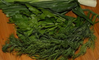 While the potatoes are baking, prepare the sauce. To do this, thoroughly wash and dry all the greens. Cut it as finely as possible with a knife on a board.