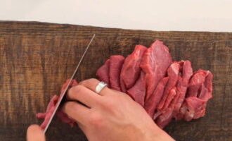 How to cook basics in Tatar style? We wash the beef and cut into thin strips. It is important to cut meat against the grain. Fry in a cauldron in vegetable oil.