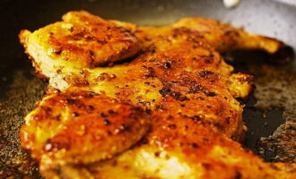 After 15 minutes, a uniform golden crust of a rather dark shade should form on the surface of the bird. Remove the press, pour a quarter cup of hot water into the pan and cover the chicken with a lid. Reduce the stove temperature to low. Cook the bird for another seven to eight minutes on each side. The chicken can then be transferred to a serving platter.