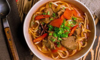 Na hora de servir, complemente o guisado com macarrão longo caseiro e decore com ervas picadas. O clássico beef lagman está pronto! Bom apetite!