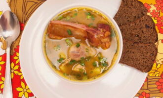 Pour hot pea soup with smoked ribs into bowls. Serve the dish to the table along with bread or crackers. Bon appetit!