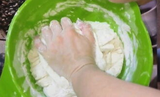 Then add sifted flour, eggs, sunflower oil and salt into the dough. When the dough becomes dense, start kneading it with your hands. To prevent the dough from sticking to your palms at the end of kneading, lubricate your hands with vegetable oil.