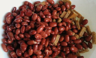 Open the can of beans and place the grains in a colander. After the excess liquid has drained, pour the beans into the crackers.