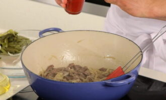 Pass the pickled cucumbers through a grater. Add them to the meat along with the onions. Cook until the onion appears lightly brown. Then add tomato paste and stir.