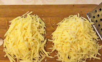 Grate the cheese on a coarse grater and divide into two equal parts.