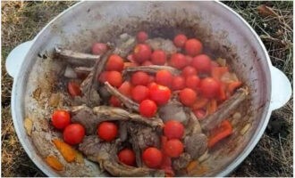 Snijd de tomaten grof, maar kleine exemplaren kunnen heel blijven. Doe ze in de ketel en bak nog eens 10 minuten.