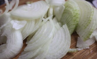 Peel the onion and cut into half rings.