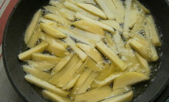 Pour vegetable oil into the frying pan and let it warm up. Afterwards, immerse the potatoes in boiling oil and salt them.