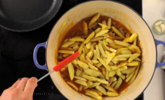 Peel the potatoes and also cut them into thin strips. Fry it separately until half cooked. Add the product to the dish, add a glass of water and simmer.