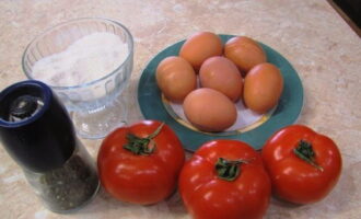 To cook scrambled eggs with tomatoes in a frying pan, first prepare all the necessary ingredients.