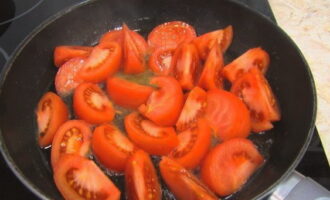 Heat a deep frying pan over high heat. Pour a small amount of vegetable oil and then add the chopped tomatoes.