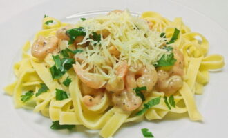 Then place on serving plates and top with shrimp and cream sauce. Rinse the parsley thoroughly under water, shake off excess moisture and finely chop with a knife. Garnish the dish with chopped herbs and Parmesan cheese. Serve shrimp pasta with creamy sauce.