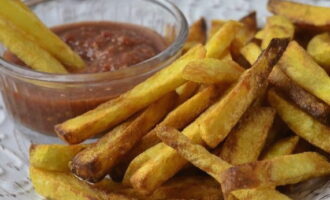 French fries in a frying pan are ready. You can add sauce and serve it to the table. 