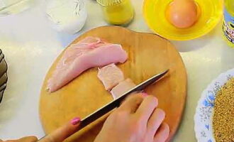 How to cook chicken nuggets at home? Remove the skin from the chicken breast, then remove the bone. Dry the resulting fillet with paper towels and cut in half lengthwise.We cut each fillet plate into longitudinal strips, which are then divided into shorter pieces across the grain. In this way, blanks for rectangular nuggets are obtained.