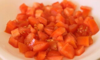 How to prepare a simple salad with red fish? We rinse the tomatoes under cold water, cut them into cubes and place in a small salad bowl. For salad, it is recommended to use firm and not too juicy vegetables so that there is no excess moisture in the dish.