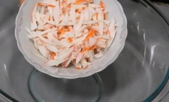 Bagaimana untuk menyediakan salad Laut Merah dengan batang ketam? Nyahbekukan batang ketam terlebih dahulu, kemudian potong menjadi jalur nipis dan masukkan bahan ke dalam mangkuk salad yang dalam.