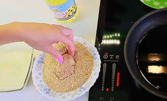 Heat odorless vegetable oil in a frying pan. Its quantity should be such that the nuggets are well fried on all sides with boiling fat. Take each piece of chicken fillet one at a time and immerse it in the egg-milk mixture. After this, roll the future nugget in breadcrumbs. If necessary, the procedure can be repeated. In this case, the breading will be more pronounced and dense. Immediately place the workpiece in hot oil.