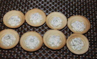 Evenly distribute the mixture of cheese and dill among the tartlets.