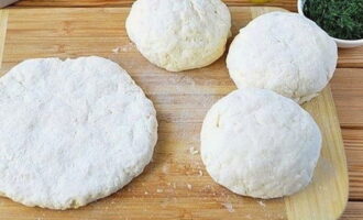 Divide the dough into four parts and roll out thin cakes. Place a little grated cheese in the middle of each flatbread, roll the dough into a ball and roll it out again.