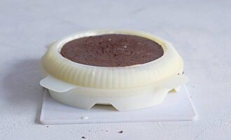 Giet de rest van de mousse uit en verdrink het chocoladekoekje erin. Er moet pure chocolademousse bovenop zitten. Zet de taart minimaal 5 uur in de vriezer. 