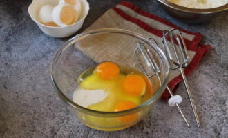 Al mismo tiempo, combine los huevos con la sal y bata hasta que la mezcla aumente de volumen. Agrega poco a poco el azúcar cristalina y de vainilla, la harina tamizada con el polvo para hornear y continúa amasando con una espátula de silicona. Es importante romper todos los grumos.