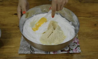 Empecemos a preparar la masa de corteza. En un bol limpio y seco (preferiblemente de cristal), batir la mezcla de claras con una pizca de sal. Como resultado, deberíamos obtener picos densos. Si no se salen del plato, entonces hicimos todo bien. Muele el azúcar restante hasta convertirlo en polvo y agrégalo a las claras. Luego trituramos las nueces en una batidora hasta que alcancen una consistencia que recuerda a la harina. Agréguelos con cuidado a la masa proteica y mezcle suavemente. No conviene remover durante mucho tiempo, ya que existe el riesgo de que las claras dejen de estar aireadas y se asienten.  