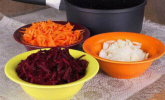 Zwiebeln, Karotten und Rüben waschen und schälen. Die Zwiebel in halbe Ringe schneiden, die Karotten und Rüben reiben. Stellen Sie eine Pfanne mit dickem Boden auf das Feuer, gießen Sie Pflanzenöl hinein, braten Sie die Zwiebel an, bis sie durchsichtig ist, und fügen Sie dann Karotten und Rüben hinzu. Das Gemüse bei schwacher Hitze 10-15 Minuten köcheln lassen.