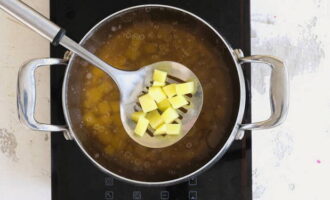 Snijd de aardappelen in kleine blokjes en dompel ze in de bereide vleesbouillon.