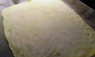 Take the risen dough and divide it into two parts, roll them out.