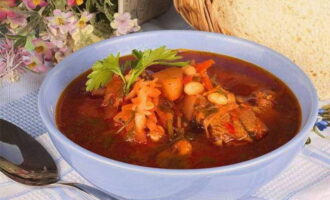 Potong kubis, masukkan ke dalam kuali, dan masak selama 20 minit. Kemudian masukkan sayur panggang dan kacang tin ke dalamnya.Akhir sekali, masukkan garam, rempah ratus dan bawang putih yang dihiris. Biarkan borscht curam di bawah tudung selama 10 minit, kemudian sajikannya.