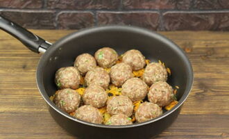 Form small balls from the minced meat and rice and place them in a frying pan with vegetables.