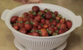 Om aardbeienjam voor de winter te maken, begin je met het bereiden van de bessen. Sorteer de aardbeien en verwijder de slechte vruchten. Daarna goed afspoelen en in een vergiet laten uitlekken.