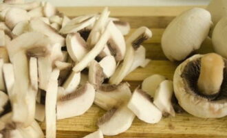 Hoe kook je champignons in zure room in een koekenpan? Dit recept gebruikt paddenstoelen als hoofdingrediënt. Ze vereisen speciale aandacht. Verwijder eerst de schil van de champignons en snijd de stengel af. Snijd vervolgens de champignons willekeurig in dunne plakjes.