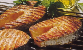 Fish steaks should be cooked on a grill grate, pre-oiled, over high heat. Before this, the fish should be coated with oil again on both sides. This will allow it to form a beautiful crispy crust when frying, and it will remain juicy inside. 