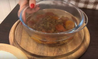 How to prepare Rotten Stump cake according to the classic recipe at home? Pour dried apricots and raisins into a bowl of hot water.