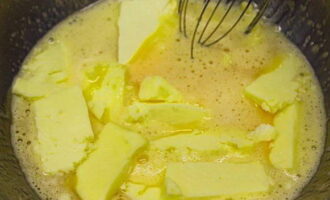 How to prepare Ryzhik cake with custard according to the classic recipe at home? Pour half the amount of sugar into a deep bowl, cut the butter into pieces and set to heat in a water bath. Mix the mixture well until the sugar is completely dissolved in the melted butter. Remove the bowl from the stove, add soda and honey, mix and set aside.