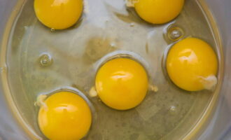 Jak ugotować puszysty omlet na parze? Weź głęboką miskę i wbij do niej każde jajko ostrą stroną noża.