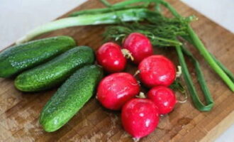 L'okroshka classique est facile et rapide à préparer à la maison. Nous lavons les concombres, les radis et les légumes verts sous l'eau. Coupez les légumes en petits cubes.