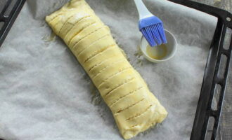 Cover the baking sheet with parchment and transfer the future pie onto it. Brush the top with yolk using a brush.