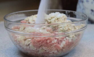 After lightly squeezing the loaf of excess moisture, add it to the minced meat. Season the mixture with salt, pepper and stir until smooth. Now you need to beat the minced meat: to do this, scoop it into your palm and forcefully throw it back into the bowl. Just don't overdo it, otherwise some of the meat will fly around the kitchen.It is not necessary to beat the minced meat, but it is very desirable that excess air comes out of it and the cutlets themselves eventually become denser, so they will hold their shape better.