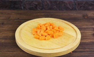 Peel the carrots and cut them into small equal-sized cubes.