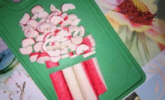 Cut the crab sticks as shown in the photo. You can also grate it on a coarse grater. Then, add crab sticks to the potatoes.